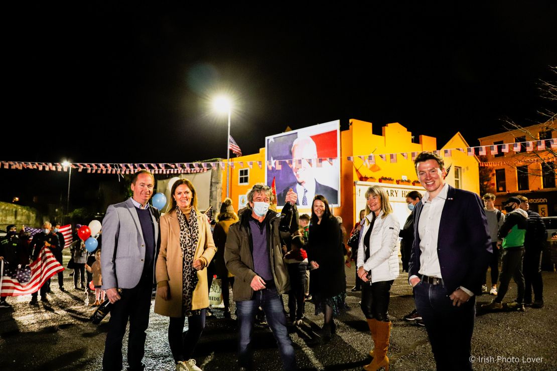 Joe Blewitt, (left), a cousin of Joe Biden, celebrates with (from left) his wife Deirdre, Smiler Mitchell, Laurita Blewitt, Emer Bourke, and local politician Mark Duffy. Behind them is a mural of Biden, recently created by Mitchell and another local artist, Leslie Lackey. 