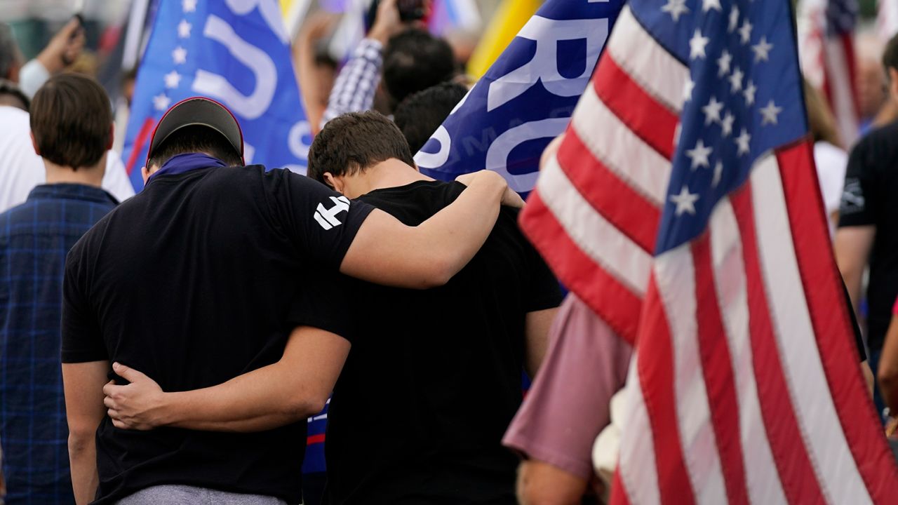 Supporters pause in prayer at a rally following President Trump's loss to President-elect Biden.