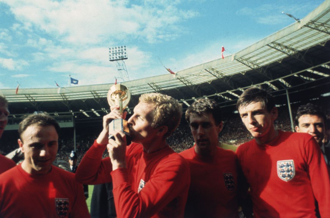 England captain Bobby Moore kisses the Jules Rimet trophy as the team celebrates winning the 1966 World Cup final.