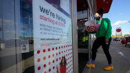 In this Sept. 30, 2020, file photo, a passerby walks past a hiring sign while entering a Target store in Westwood, Mass. 