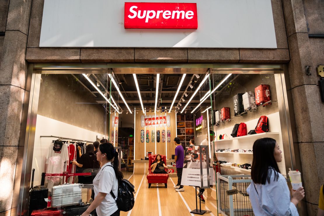  Pedestrians walk past an American skateboarding shop and clothing brand Supreme store in Shanghai on September 9, 2019.