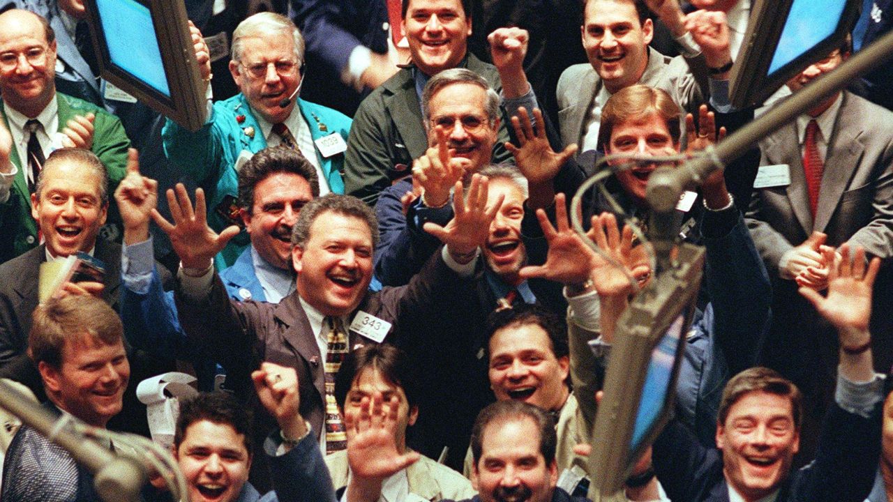 Traders cheer on the floor of the New York Stock Exchange in March 1999, as the Dow hit the 10,000  mark for the first time. By the end of the month it would close above that level.