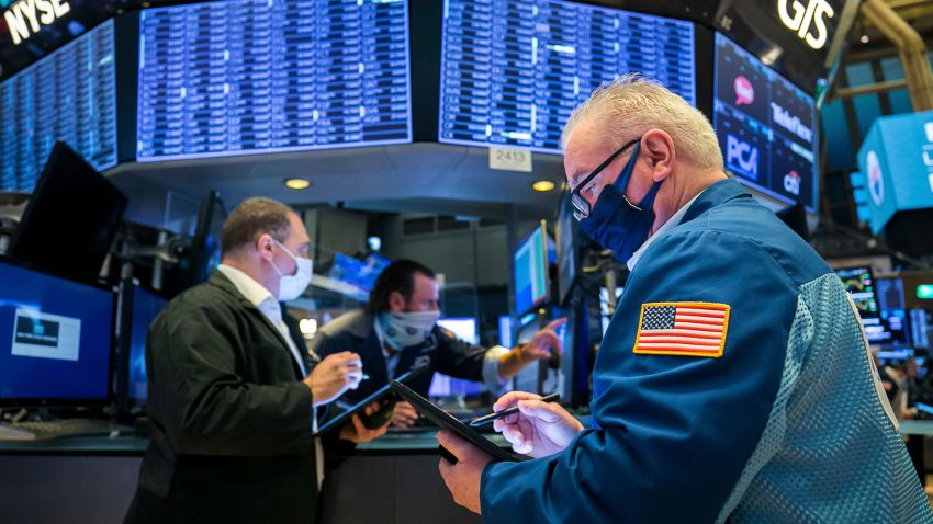 In this photo provided by the New York Stock Exchange, James Dresch, right, works with fellow traders on the floor, Monday Nov. 9, 2020. Stocks around the world are surging Monday, sending Wall Street back to record heights, on a burst of hope following encouraging data for a potential COVID-19 vaccine from Pfizer. (Courtney Crow/New York Stock Exchange/AP)