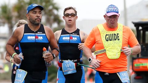 Chris Nikic and his guide Dan Grieb, right, competes in the run course of Ironman Florida.