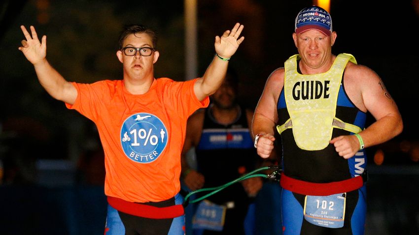 PANAMA CITY BEACH, FLORIDA - NOVEMBER 07: Chris Nikic and his guide Dan Grieb cross the finish line of IRONMAN Florida on November 07, 2020 in Panama City Beach, Florida. Chris Nikic became the first Ironman finisher with Down syndrome. (Photo by Michael Reaves/Getty Images for IRONMAN)
