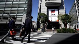 Pedestrians cross a road in front of the Tokyo Stock Exchange (TSE), operated by Japan Exchange Group Inc. (JPX), in Tokyo, Japan, on Thursday, Oct. 29, 2020.