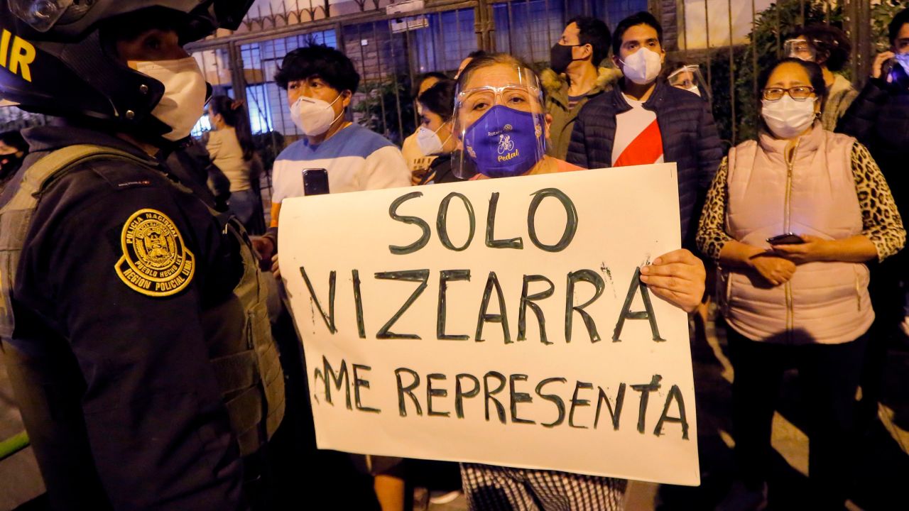 A woman displays a banner reading 'Only Vizcarra represents me' in Spanish as former President Vizcarra arrives home in Lima on November 9.