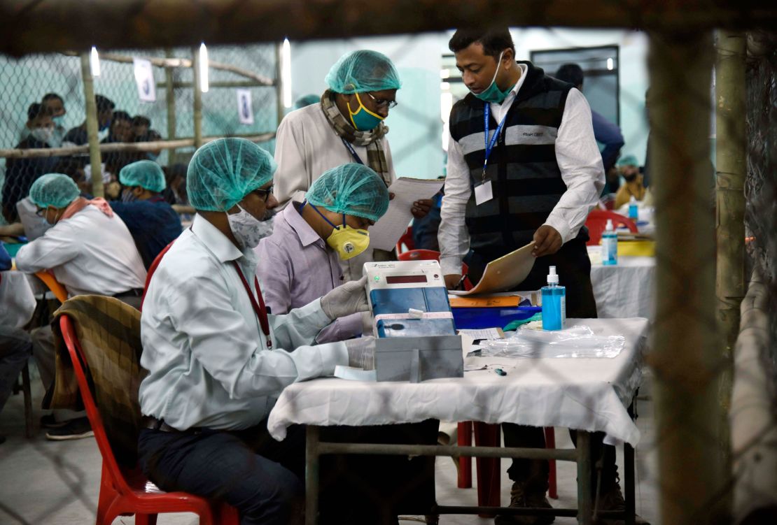 Election officers wearing face masks count votes for the Bihar state assembly polls, at a counting centre in Patna, India, on November 10, 2020. 