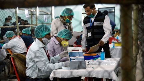 Election officers wearing face masks count votes for the Bihar state assembly polls, at a counting centre in Patna, India, on November 10, 2020.