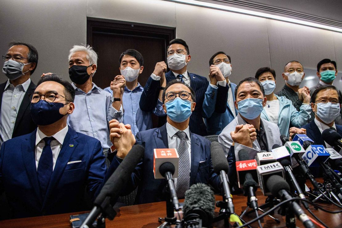Hong Kong pro-democracy lawmakers join hands at a press conference pledging their resignation, on November 11.