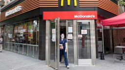 A medical worker wearing a mask walks out of a McDonald's near a 'you must wear a mask' sign displayed at the entrance as the city enters Phase 4 of re-opening following restrictions imposed to slow the spread of coronavirus on July 24, 2020 in New York City. McDonald's announced that it will require customers to wear masks. The fourth phase allows outdoor arts and entertainment, sporting events without fans and media production. (Photo by Alexi Rosenfeld/Getty Images)
