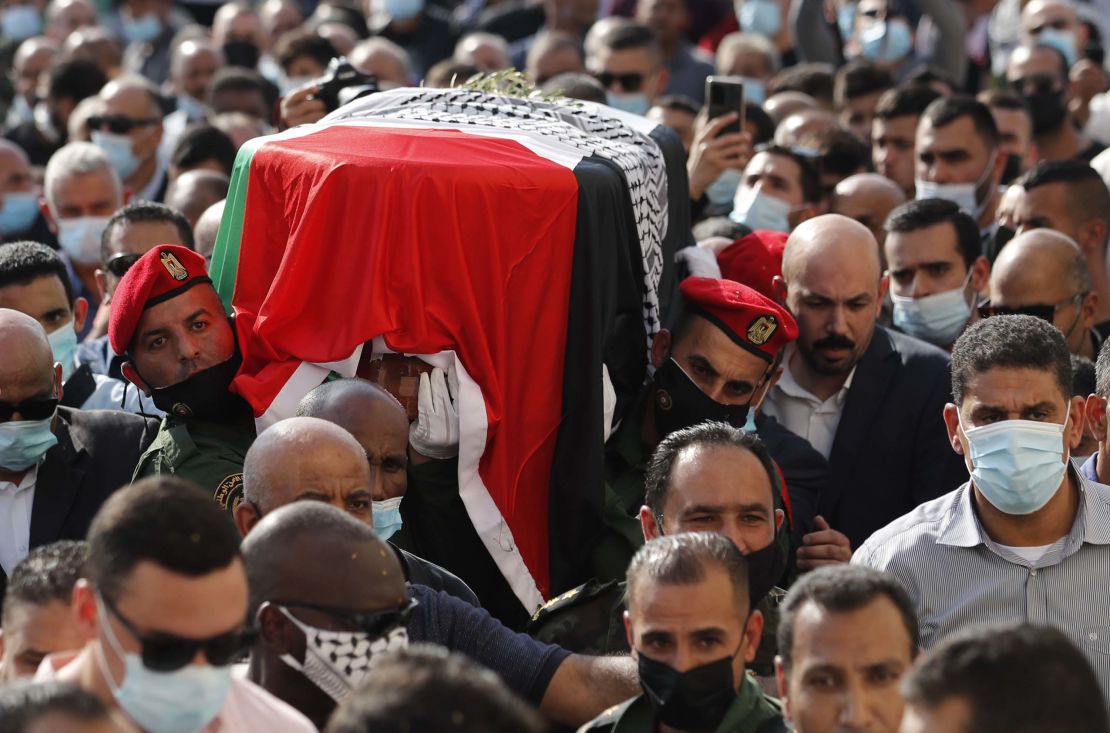 Palestinian mourners and an honor guard carry the coffin of Saeb Erekat during his funeral procession.