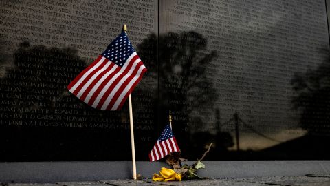 A flower and two American flags are left at the base of the Vietnam Veterans Memorial Wall on Veterans Day on November 11, 2020 in Washington, DC