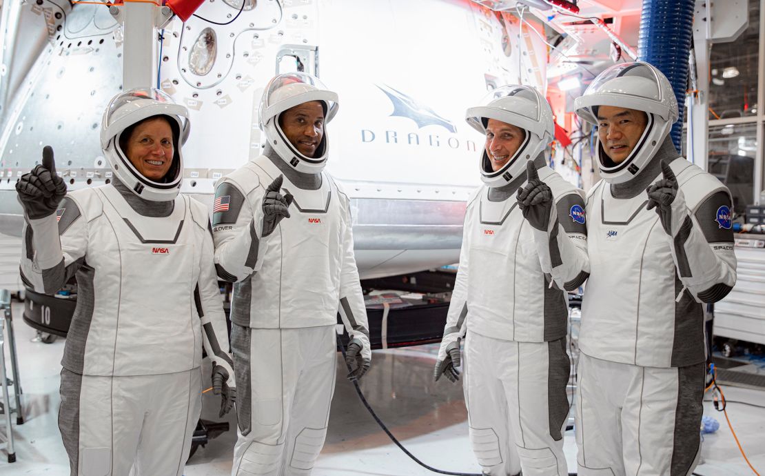 In this Thursday, Sept. 24, 2020, image released by SpaceX/NASA, NASA's SpaceX Crew-1 astronauts, from left, mission specialist Shannon Walker, pilot Victor Glover, and Crew Dragon commander Michael Hopkins, all NASA astronauts, and mission specialist Soichi Noguchi, Japan Aerospace Exploration Agency (JAXA) astronaut, gesture during crew equipment interface testing at SpaceX headquarters in Hawthorne, Calif. SpaceX's second astronaut flight is off until mid-November 2020 because red lacquer dripped into tiny vent holes in two rocket engines that now must be replaced. (SpaceX/NASA via AP)