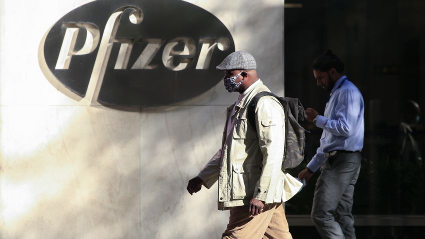 TOPSHOT - People walk by the Pfizer world headquarters in New York on November 9, 2020. - Pfizer stock surged higher on November 9, 2020 prior to the opening of Wall Street trading after the company announced its vaccine is "90 percent effective" against Covid-19 infections. The news cheered markets worldwide, especially as coronavirus cases are spiking, forcing millions of people back into lockdown. (Photo by Kena Betancur / AFP) (Photo by KENA BETANCUR/AFP via Getty Images)