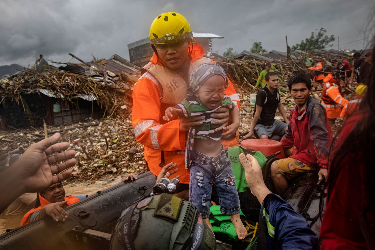 A rescuer carries a child in Rodriguez on November 12.