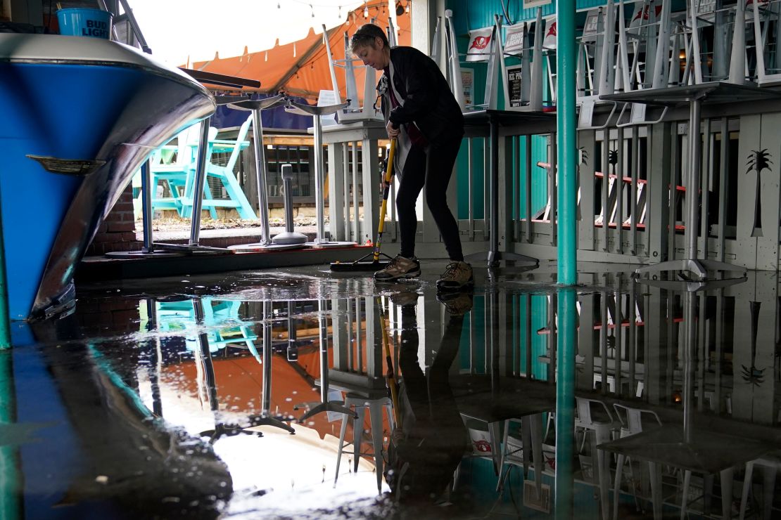 Kate Connell sweeps water and mud from the floor at Salty's bar in Gulfport, Florida, in the aftermath of Tropical Storm Eta on Thursday.