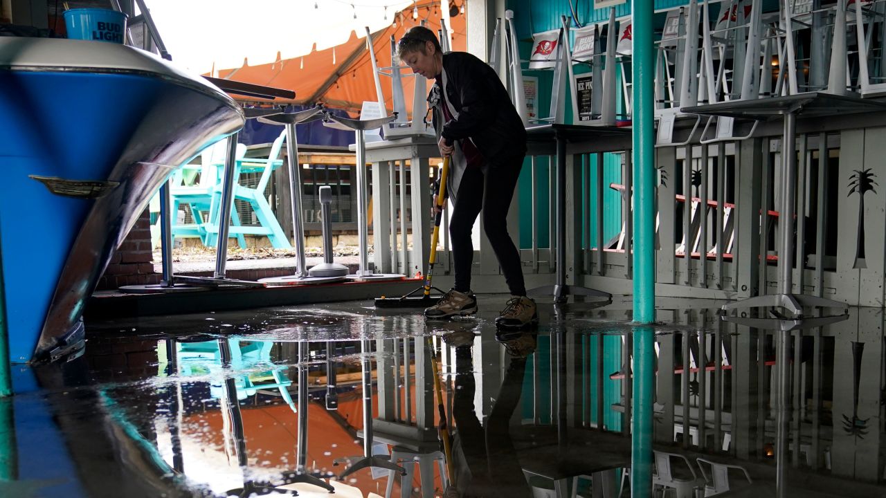 Kate Connell sweeps water and mud from the floor at Salty's bar in Gulfport, Florida, in the aftermath of Tropical Storm Eta on Thursday.