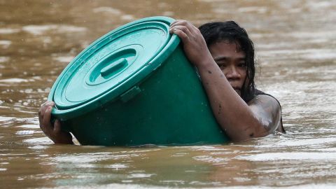 A Marikina resident clings to a plastic container as floodwaters hit the area.