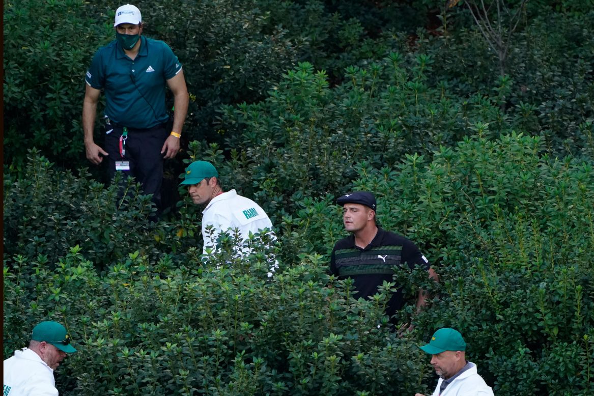Caddies and course officials help pro golfer Bryson DeChambeau, second from right, look for his ball during the first round of the Masters on Thursday, November 12.