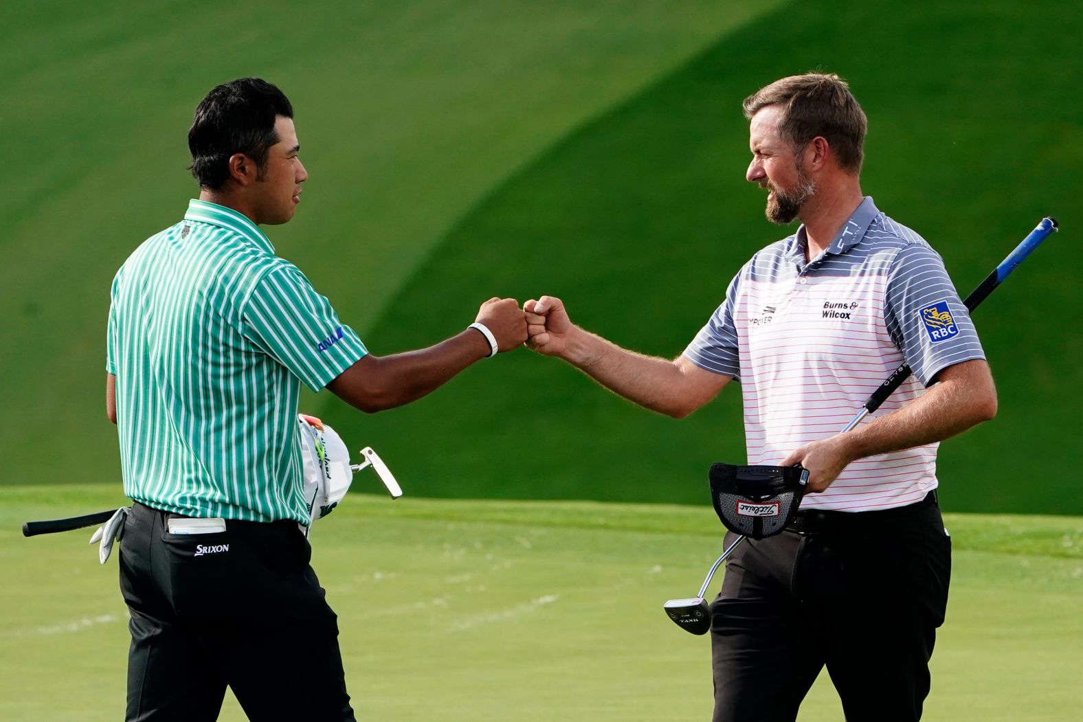 Webb Simpson (right) fist pumps Hideki Matsuyama (left) on the ninth hole after their first round.