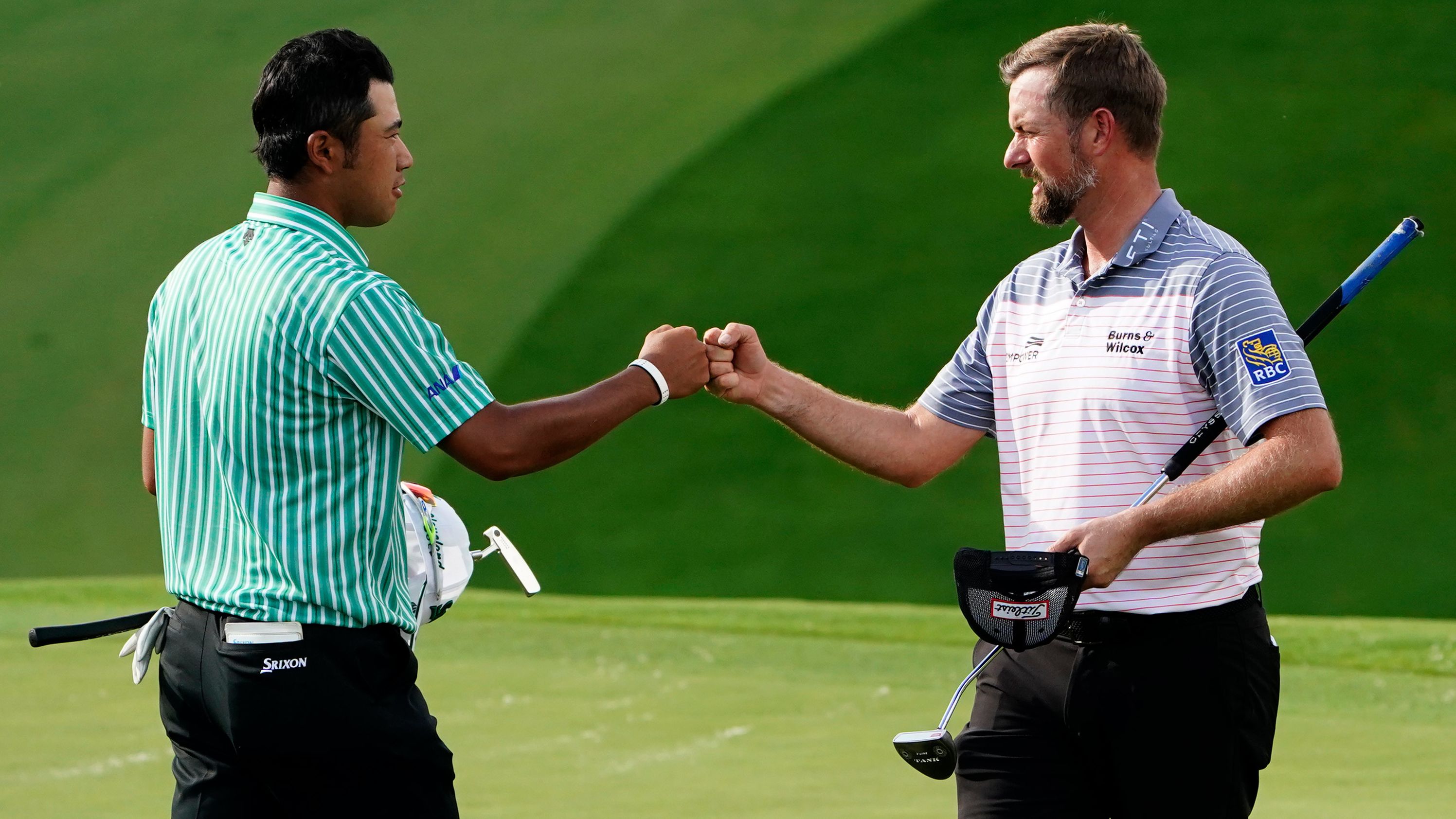 Webb Simpson (right) fist pumps Hideki Matsuyama (left) on the ninth hole after their first round.