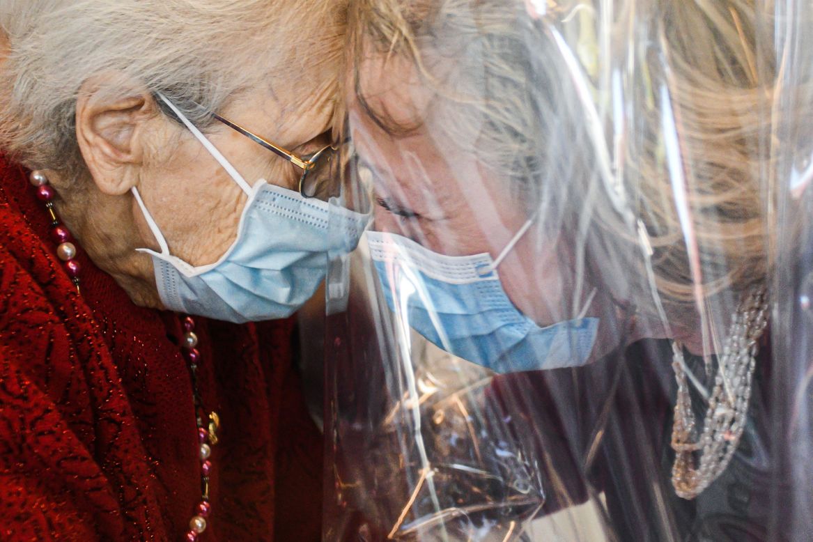 A nursing-home resident, left, speaks with her visiting daughter through a plastic screen in Castelfranco Veneto, Italy, on Wednesday, November 11. The plastic screen is part of a "Hug Room" that allows residents and their families to embrace each other during the coronavirus pandemic.