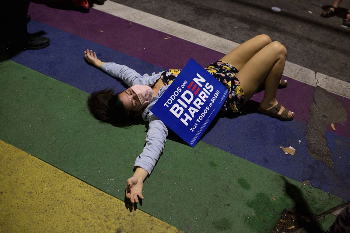 Laurane Palace lies on a rainbow crosswalk in Atlanta while <a href="http://www.cnn.com/2020/11/07/politics/gallery/america-reacts-to-new-president-2020/index.html" target="_blank">people celebrate Joe Biden's victory</a> in the US presidential election on Saturday, November 7.