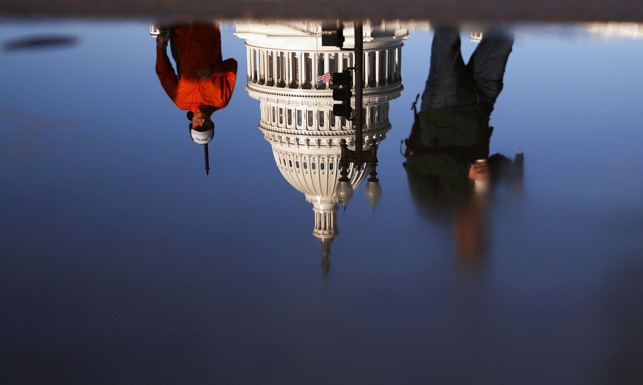 The US Capitol building is reflected in a puddle in Washington, DC, on Tuesday, November 10.