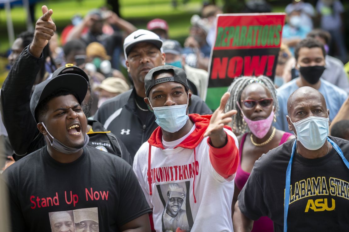 A group of protesters shout at two Cobb County investigators outside the Glynn County Courthouse during a June 4 preliminary hearing for the suspects in Arbery's shooting.