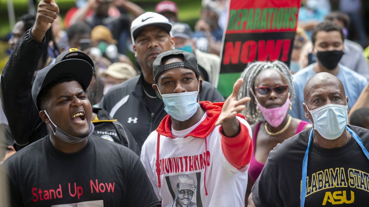 A group of protesters shout at two Cobb County investigators outside the Glynn County Courthouse during a June 4 preliminary hearing for the suspects in Arbery's shooting.