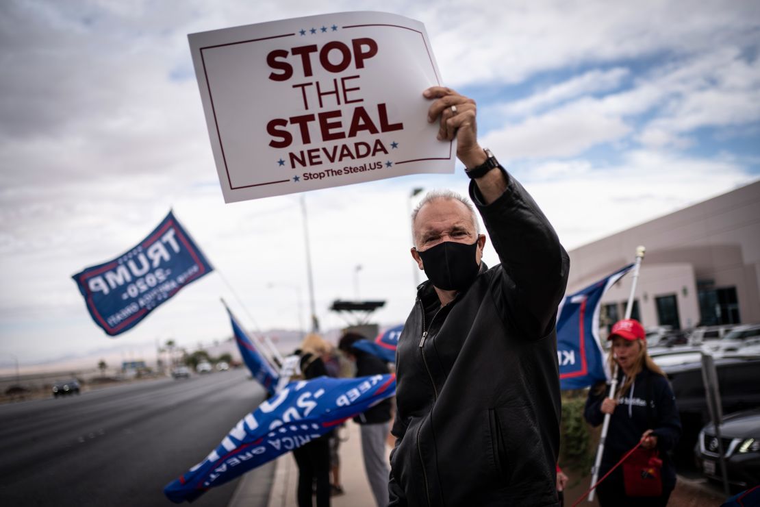 Supporters of President Donald Trump hold "Stop the Steal" signs as they stand outside of the Clark County Elections Department in Nevada on November 7.