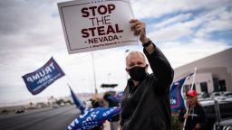 Supporters of President Donald Trump hold signs as they stand outside of the Clark County Elections Department in North Las Vegas, Nev. Saturday, Nov. 7, 2020. (AP Photo/Wong Maye-E)