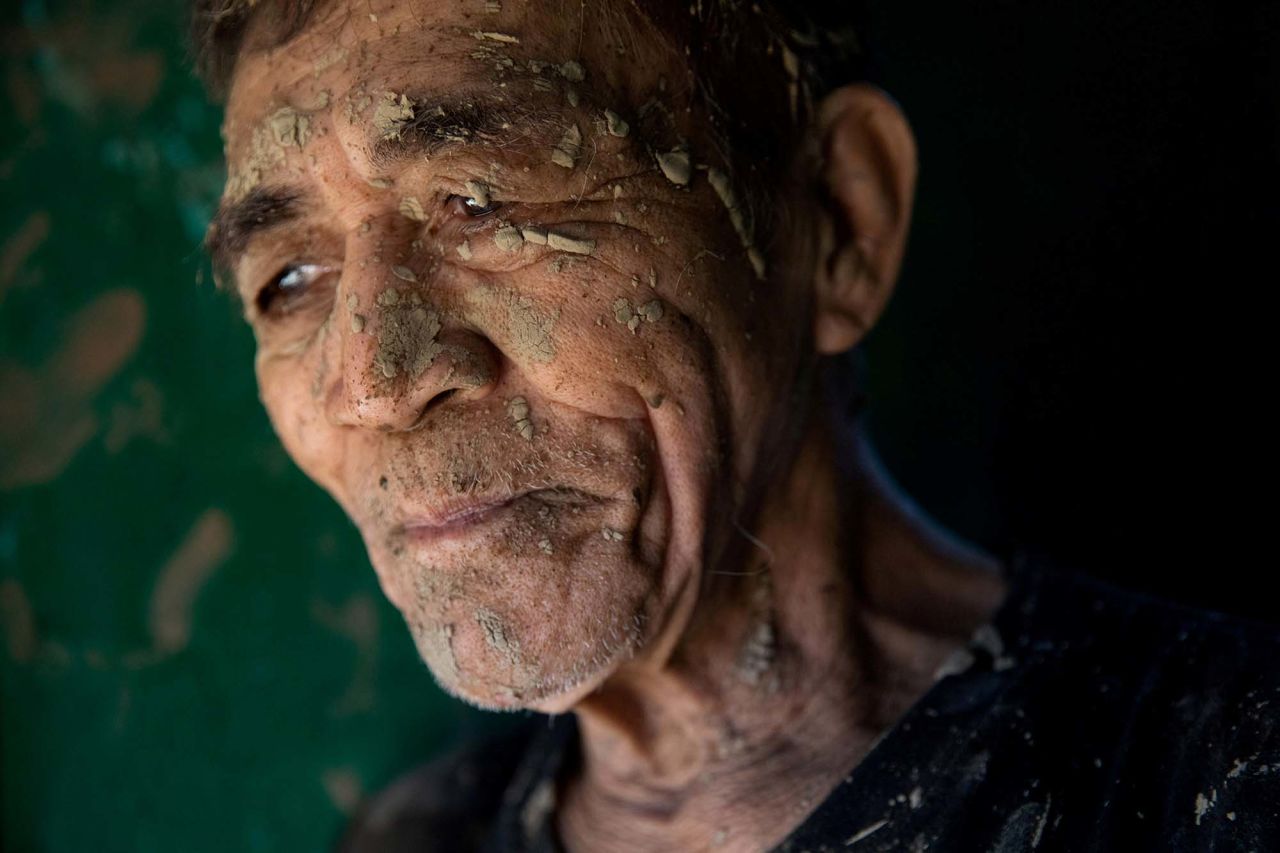 A man takes a break from cleaning his house, which was covered in mud in San Mateo on November 13.