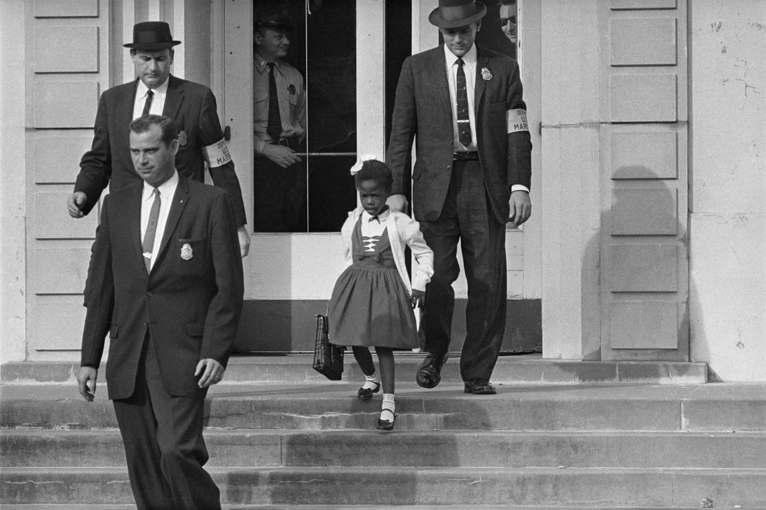 US deputy marshals escort 6-year-old Ruby Bridges from William Frantz Elementary School in New Orleans. 