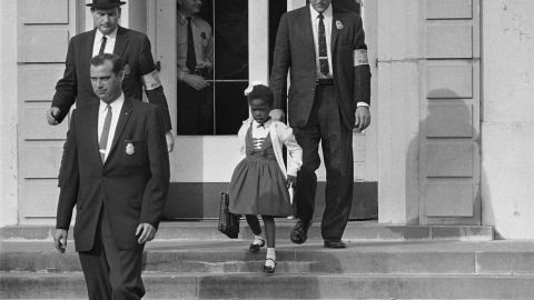 US deputy marshals escort 6-year-old Ruby Bridges from William Frantz Elementary School in New Orleans.