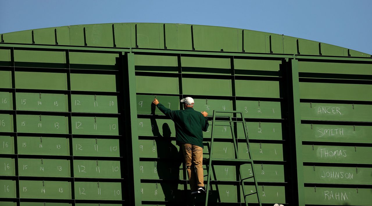  A course worker updates the scoreboard on the eighth green during the third round.