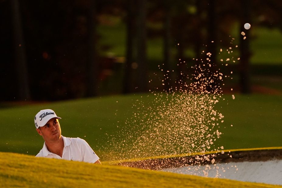 Justin Thomas watches his shot out of a bunker on the 18th hole which he eventually bogeyed to fall six behind Johnson.