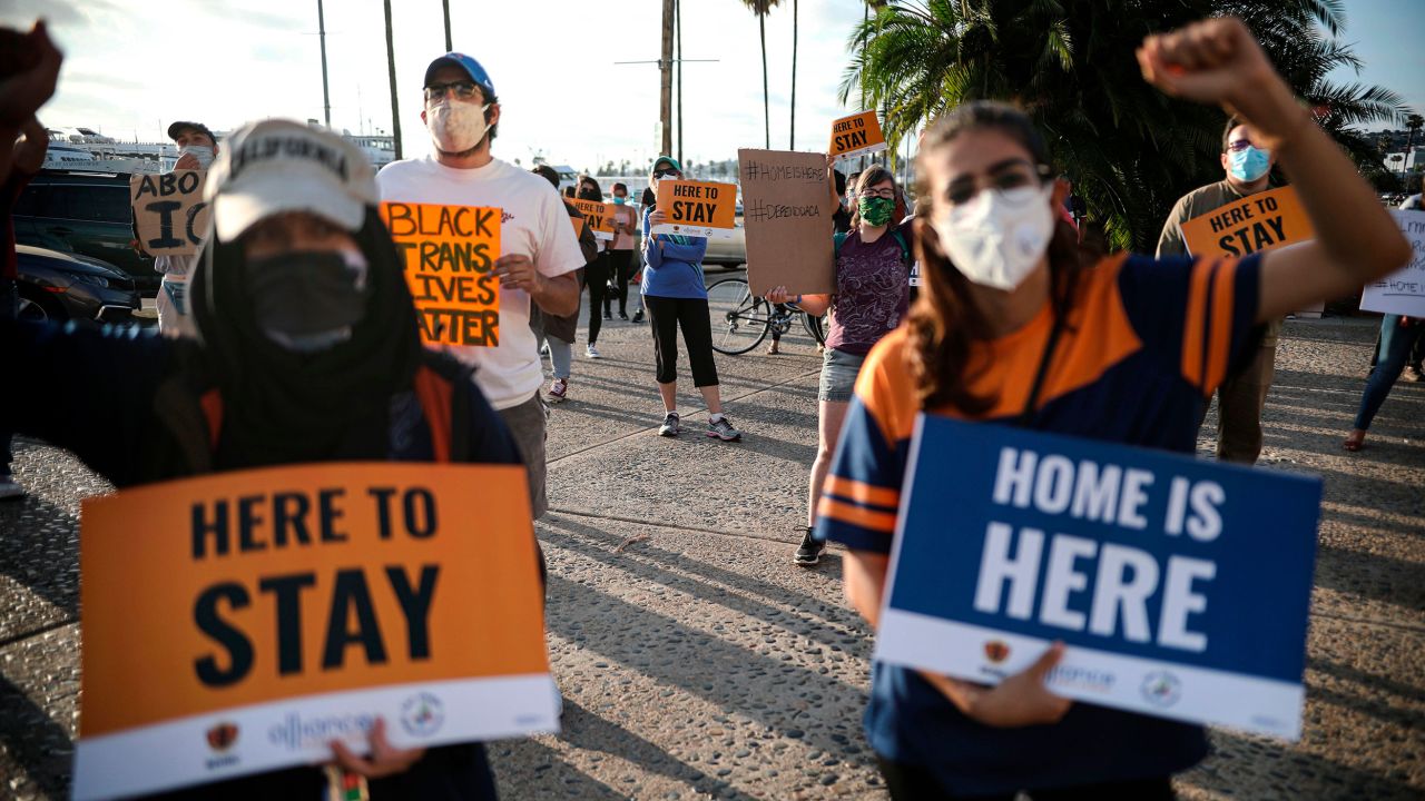 People hold signs during a rally in support of the Supreme Court's ruling in favor of the DACA program, in San Diego, June 18, 2020. 