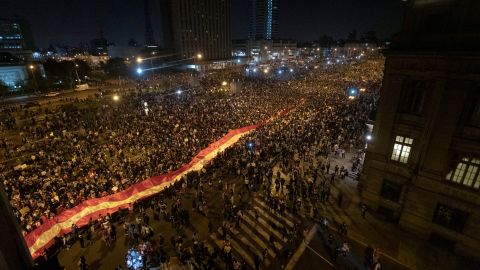 Protesters against the removal of President Martin Vizcarra march with a giant national flag as they gather in front of Palacio de Justicia on November 14, 2020 in Lima, Peru. 