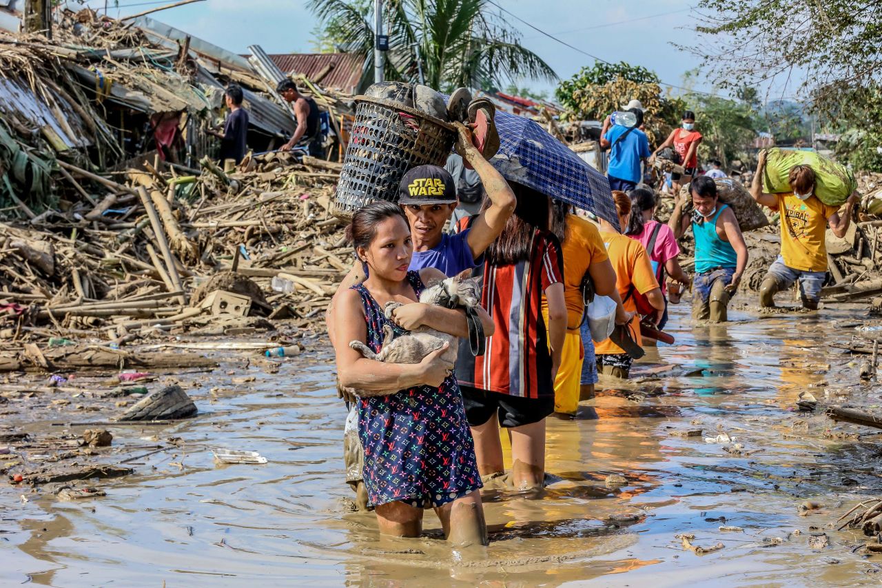 Residents walk knee-deep in mud as they retrieve their belongings after the flood brought by Typhoon Vamco in Rizal Province on November 14.