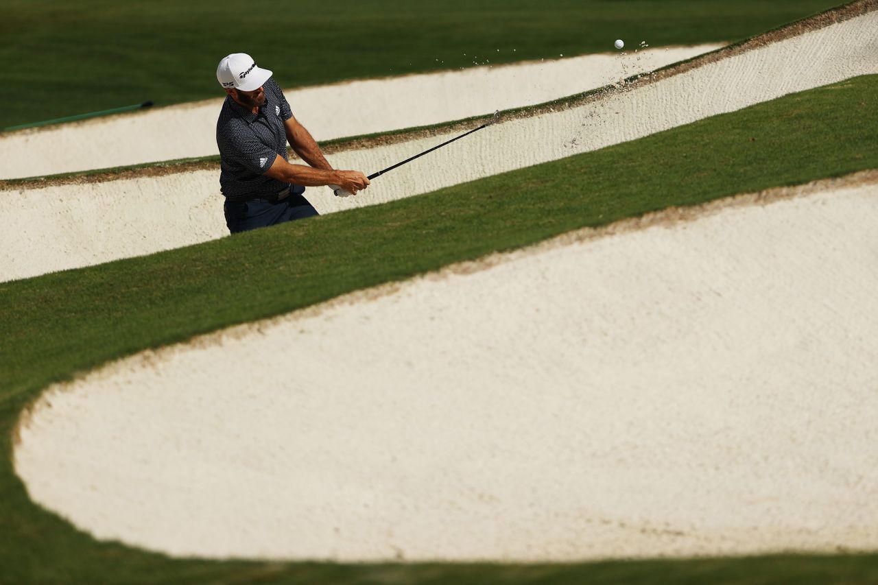Dustin Johnson of the United States plays a shot from a bunker on the seventh hole.