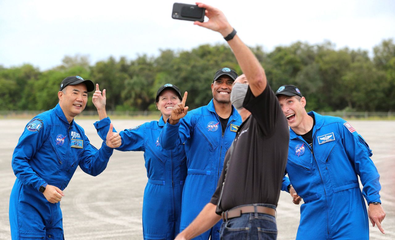 The crew of the SpaceX Crew-1 mission pose for a photo with a SpaceX employee on November 8 at Kennedy Space Center.