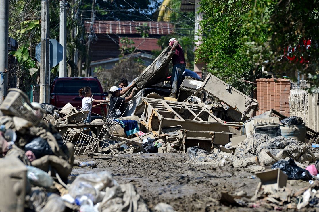 People try to recover belongings amid mud after the passage of Hurricane Eta as they prepare to evacuate the Omonita neighborhood in El Progreso, Yoro department, Honduras.