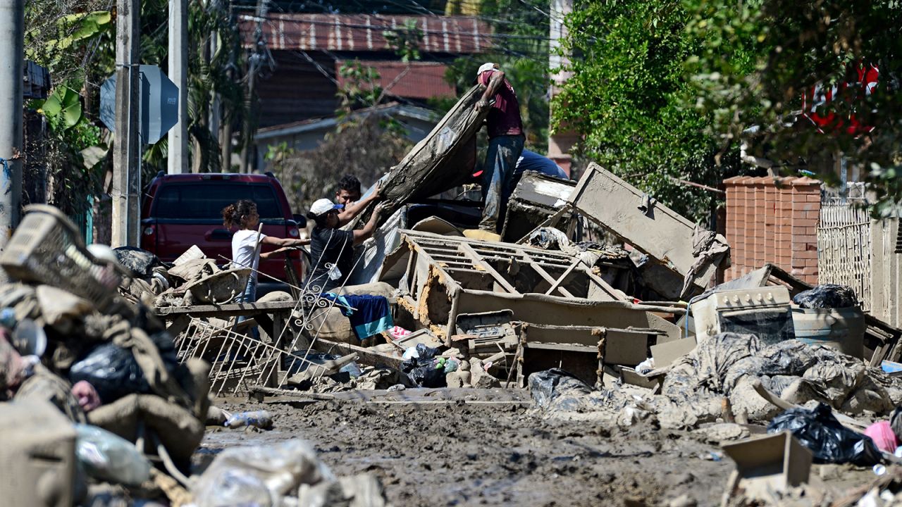 People try to recover belongings amid mud after the passage of Hurricane Eta as they prepare to evacuate the Omonita neighborhood in El Progreso, Yoro department, Honduras.