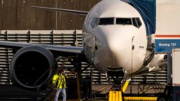 A worker walks by a Boeing 737 Max airplane as it sits parked at the company's Renton production facility on November 13, 2020 in Renton, Washington. Boeing has announced new cancellations of orders of the plane as it readies for approval to fly it again. (Photo by David Ryder/Getty Images)
