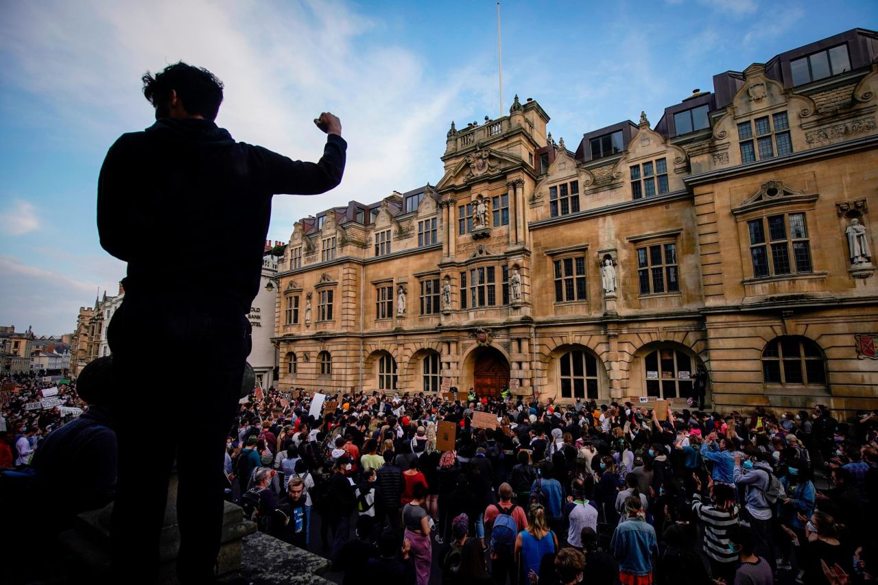 A demonstration takes place opposite a statue of Cecil Rhodes at the University of Oxford. 