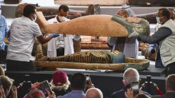Archaeologists examine a mummy inside a newly discovered coffin on Nov. 14, 2020, in Saqqara near Cairo. Egypt's Ministry of Tourism and Antiquities announced the same day that at least 100 ancient coffins, buried more than 2,500 years ago, were found in the Pharaonic necropolis in Saqqara. (Photo by Kyodo News via Getty Images)