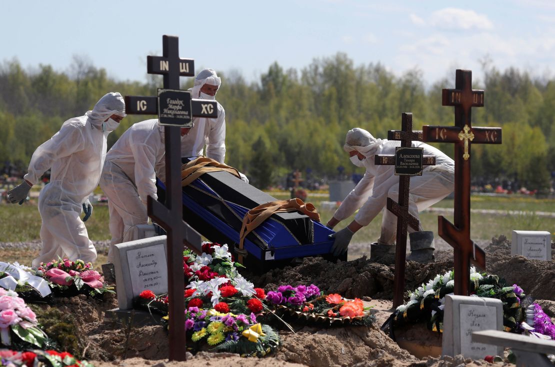 Workers wear protective equipment in Novoye Kolpinskoye Cemetery, Saint Petersburg, during a funeral in May.