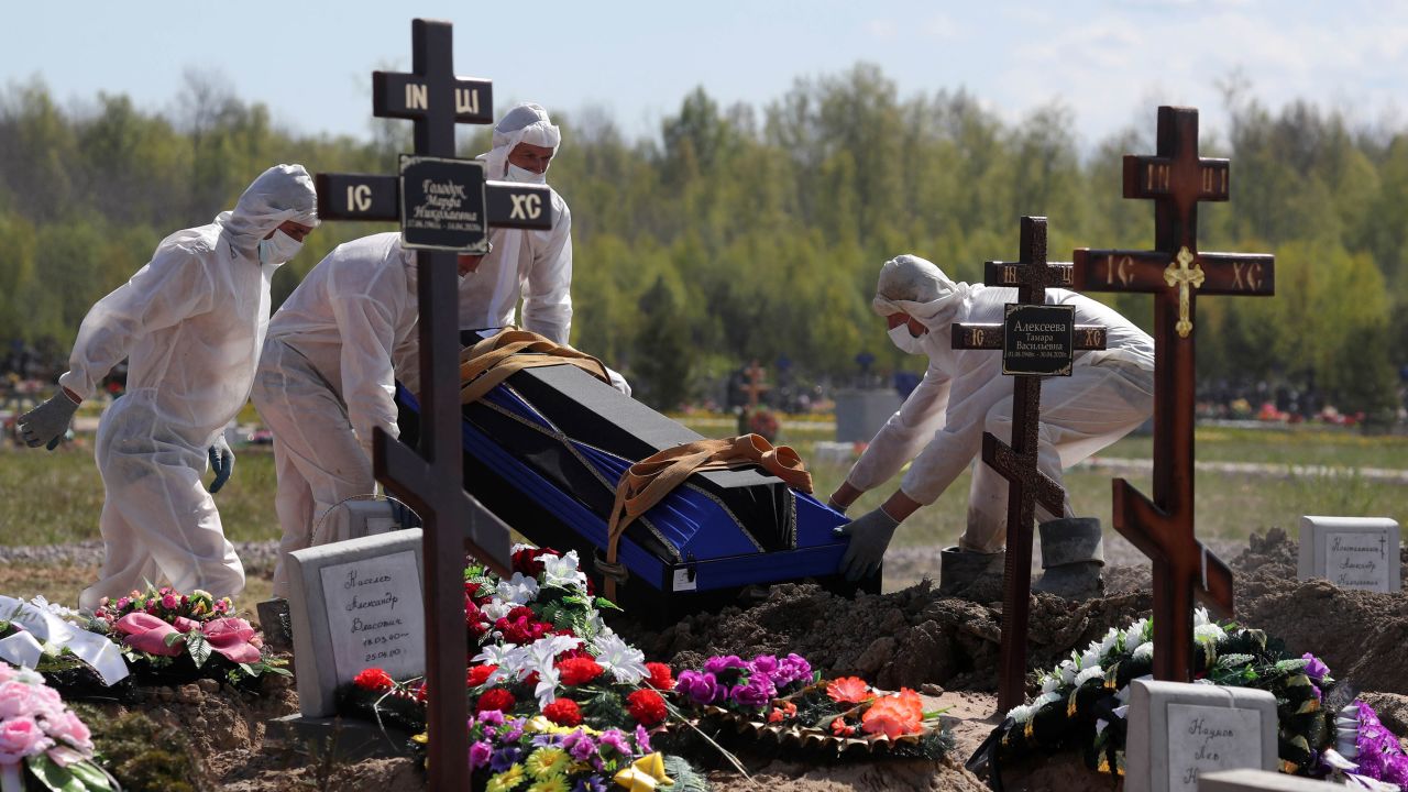Workers wear protective equipment in Novoye Kolpinskoye Cemetery, Saint Petersburg, during a funeral in May.